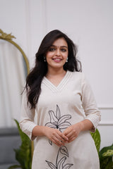 Woman wearing a white dress with black floral embroidery in a co-ord set - Vastra Gehna