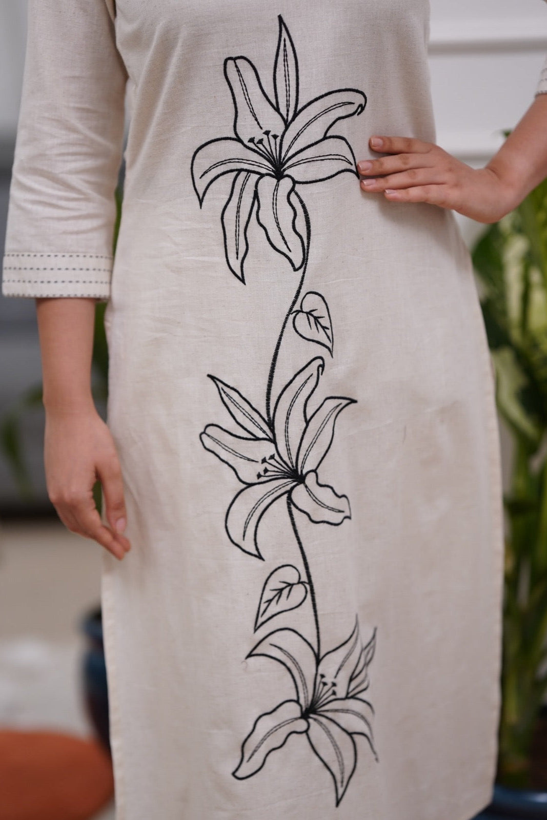 Woman wearing a white dress with black floral embroidery in a co-ord set - Vastra Gehna