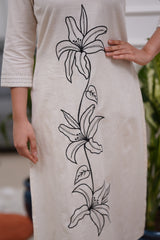 Woman wearing a white dress with black floral embroidery in a co-ord set - Vastra Gehna