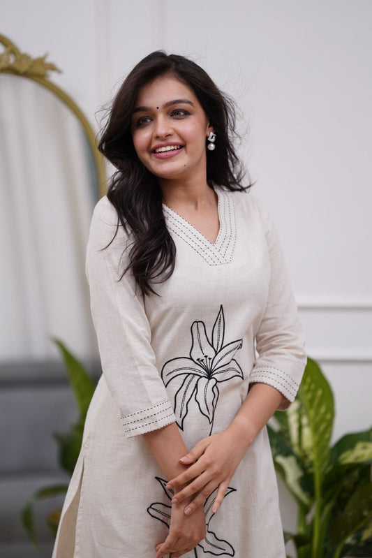 Woman wearing a white dress with black floral embroidery in a co-ord set - Vastra Gehna