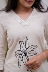 Woman wearing a white dress with black floral embroidery in a co-ord set - Vastra Gehna